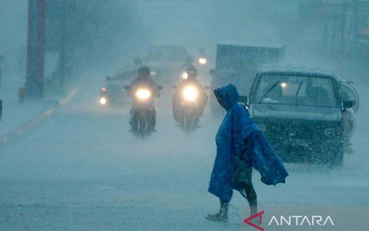 Ilustrasi - Seorang warga melintas diantara pengendara bermotor yang melintasi jalan Laksda Adisucipto saat terjadi hujan yang lebat di Yogyakarta. ANTARA FOTO/Wahyu Putro A/ed/nz.