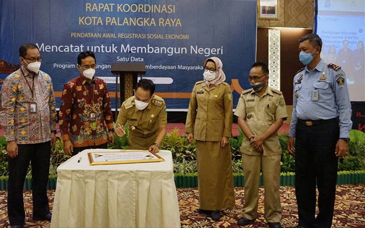 Wali Kota Palangka Raya Fairid Naparin menandatangani pendataan awal Regsosek. (FOTO: DISKOMINFO)