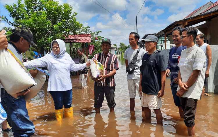Ketua PMI Kobar Nurhidayah menyerahkan bansos untuk korban banjir di Kelurahan Mendawai. (FOTO : DANANG)