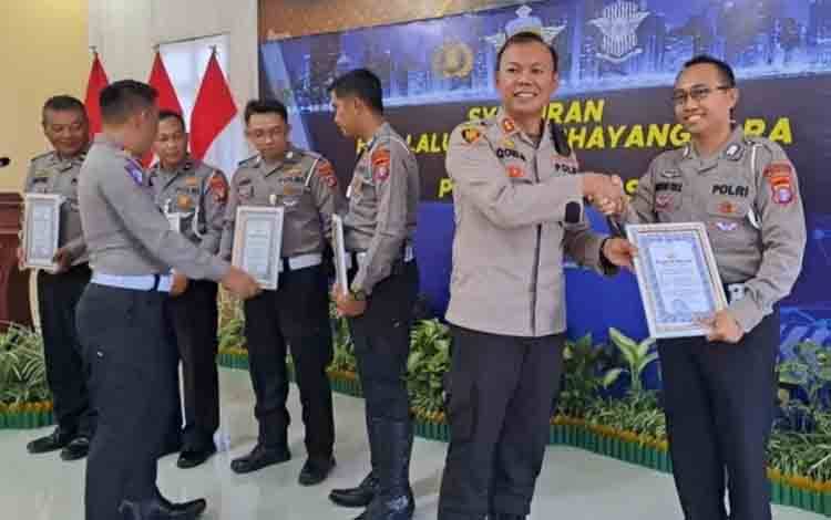 Kapolres Kapuas AKBP Qori Wicaksono saat menyerahkan penghargaan kepada personel Satlantas Polres Kapuas. (FOTO: POLRES KAPUAS)
