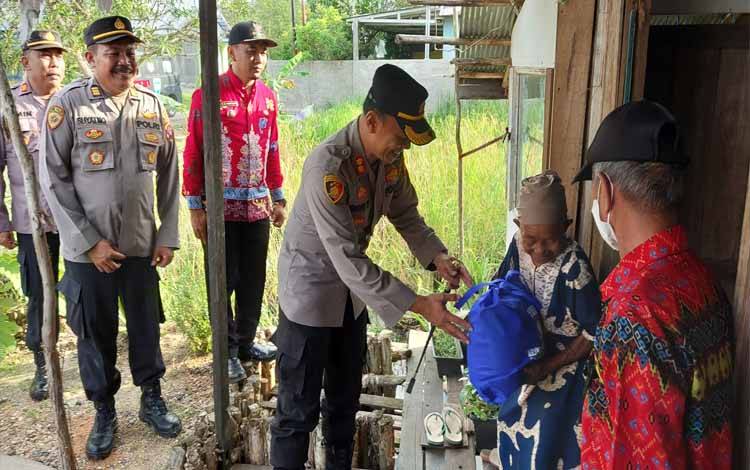Kapolres Kapuas AKBP Qori Wicaksoni menyerahkan bantuan kepada warga di Jalan Antasari, Kelurahan Selat Utara, Kecamatan Selat, Jumat sore, 23 September 2022. (FOTO: DODI)