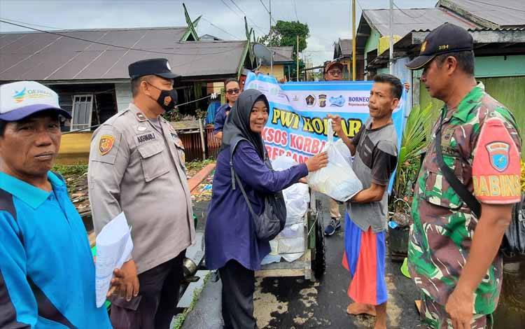 Anggota PWI Kobar menyalurkan bansos untuk korban banjir di Kelurahan Raja Seberang. (FOTO : DANANG)