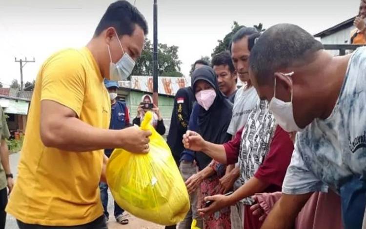 Bupati Lamandau Hendra Lesmana menyerahkan bantuan kepada warga terdampak banjir di Kelurahan Nanga Bulik, Kecamatan Bulik. (FOTO : HENDI NURFALAH)