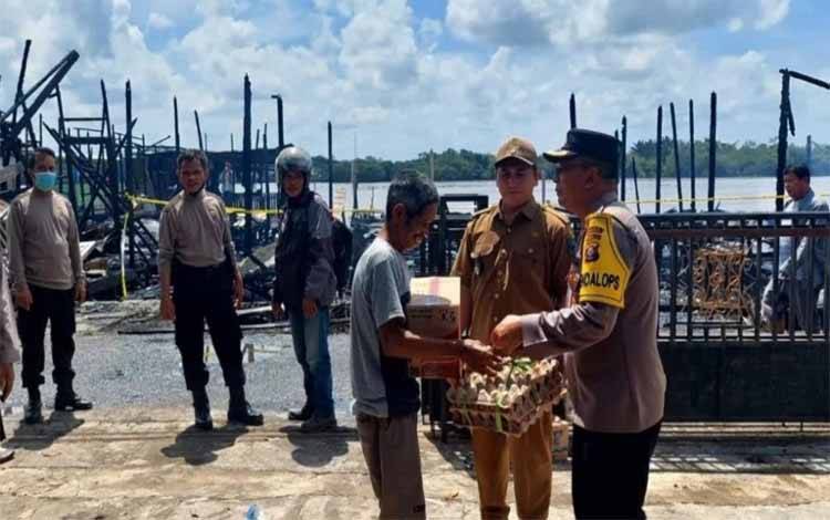Kabag Ops Polres Kapuas Kompol Edia Sutaata meninjau dan menyerahkan bantuan warga terdampak kebakaran di Desa Saka Mangkahai. (FOTO: IST)