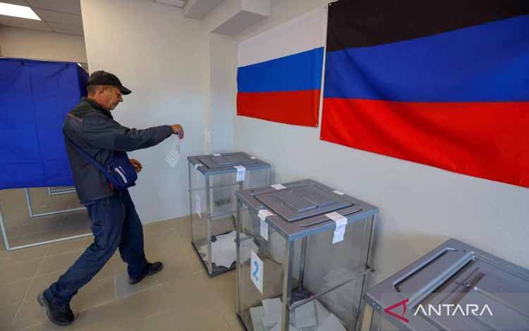 Seorang warga memasukkan surat suaranya ke dalam kotak suara di Tempat Pemungutan Suara pada hari kedua Referendum Republik Rakyat Donetsk bergabung dengan Rusia di Mariupol, Ukraina, Sabtu (24/9/2022). Rusia mulai menggelar pemungutan suara dalam referendum tersebut pada Jumat (23/9/2022) di Republik Rakyat Donetsk dan Luhansk, juga digelar di dua wilayah pendudukan lain, yakni Zaporizhzhia dan Kerhson yang akan berlanjut hingga Selasa (27/9/2022) mendatang. ANTARA FOTO/REUTERS/Alexander Ermoch