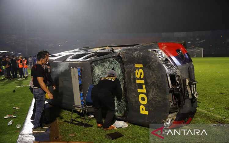 Sebuah mobil polisi terbalik akibat kericuhan usai pertandingan BRI Liga 1 antara Arema melawan Persebaya di Stadion Kanjuruhan, Malang, Jatim, Minggu (2/10/2022). Sebanyak 127 orang dilaporkan meninggal dunia dalam kerusuhan tersebut. ANTARA FOTO/H Prabowo/pras