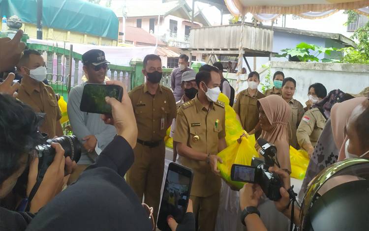 Wali Kota Palangka Raya Fairid Naparin menyerahkan sembako murah kepada warga di Kelurahan Pahandut. (FOTO: HENDRI)