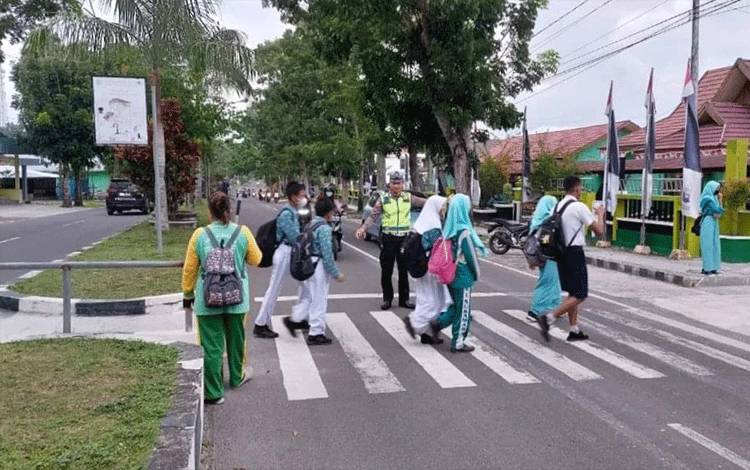 Anggota Satlantas Polres Sukamara saat mengatur lalulintas didelan sekolah SMP Negeri 1 Sukamara. (FOTO: NORHASANAH)
