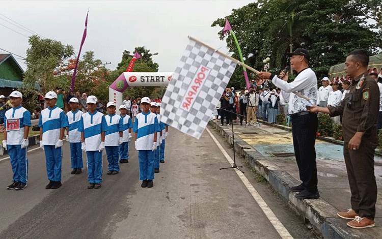 Bupati SukamaraWindu Subagyo melepas peserta lomba gerak jalan di depan Lapangan Koramil, Selasa, 18 Oktober 2022. (FOTO: NORHASANAH)