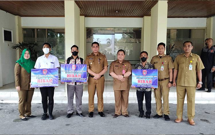 Pj Bupati Kobar Anang Dirjo didampingi Plt Sekda Kobar Juni Gultom, foto bersama penerima hibah dan sejumlah pejabat SOPD.