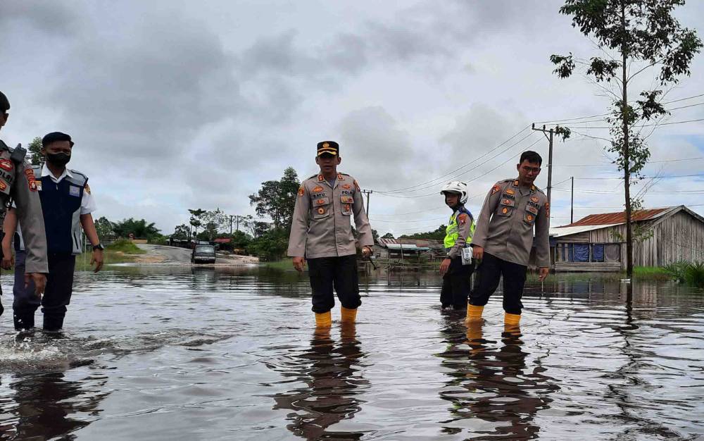 Kapolres Kobar AKBP Bayu Wicaksono didampingi Kabagops saat meninjau banjir di Jalan Poros Pangkalan Bun - Kotawaringin Lama. (FOTO : DANANG)