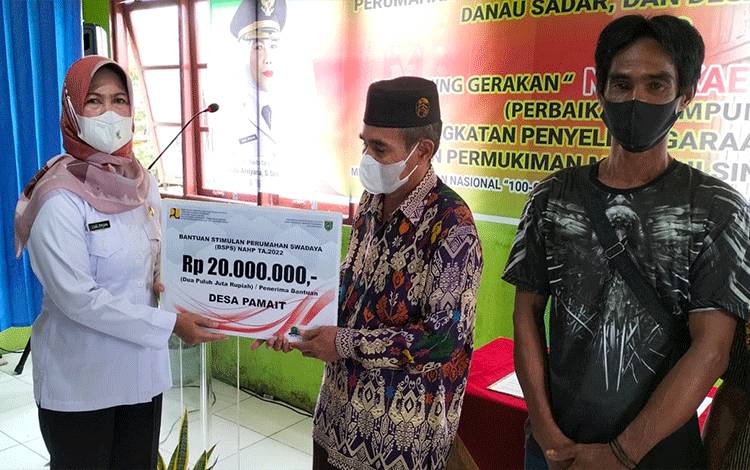 Pj Bupati Barito Selatan, Lisda Arriyana menyerahkan baku tabungan bagi masyarakat berpenghasilan rendah penerima BSPS. (FOTO : URIUTU DJAPER)