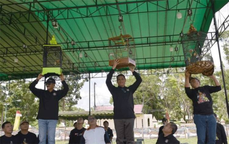 Pj Bupati Kobar Anang Dirjo (tengah) didampingi Wakil Ketua I DPRD Kobar Mulyadin dan Danlanud Iskandar Pangkalan Bun, menaikan sangka burung ke gelanggang sebagai tanda dimulainya Turnamen Burung Berkicau DPRD Cup II.