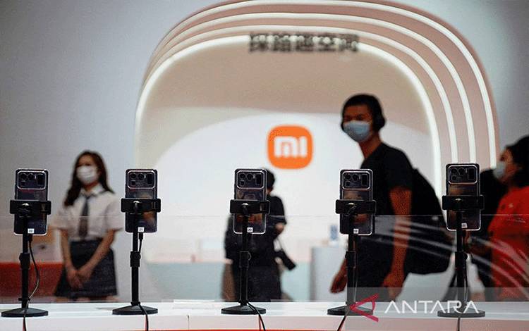 Pemandangan ponsel di depan logo Xiaomi di China Digital Entertainment Expo and Conference, juga dikenal sebagai ChinaJoy, di Shanghai, China (30/7/2021). ANTARA/REUTERS/Aly Song/aa. (REUTERS/ALY SONG)