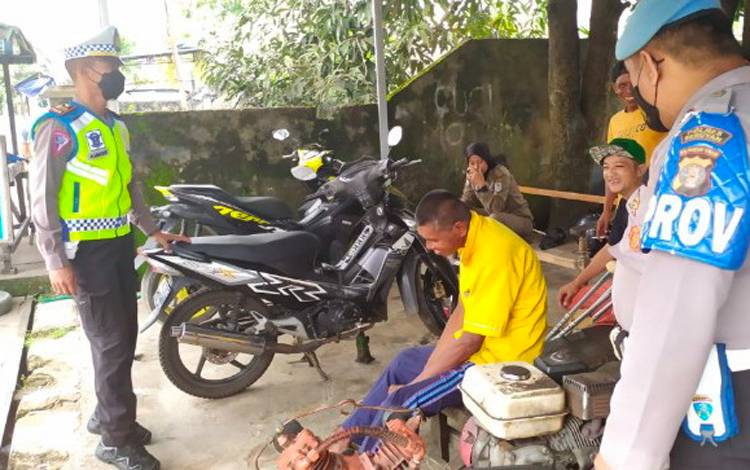 Personel Satuan Lalu Lintas Polres Seruyan, menyambangi salah satu bengkel untuk memberikan sosialisasi terkait larangan penggunaan knalpot brong. (FOTO: FAHRUL)