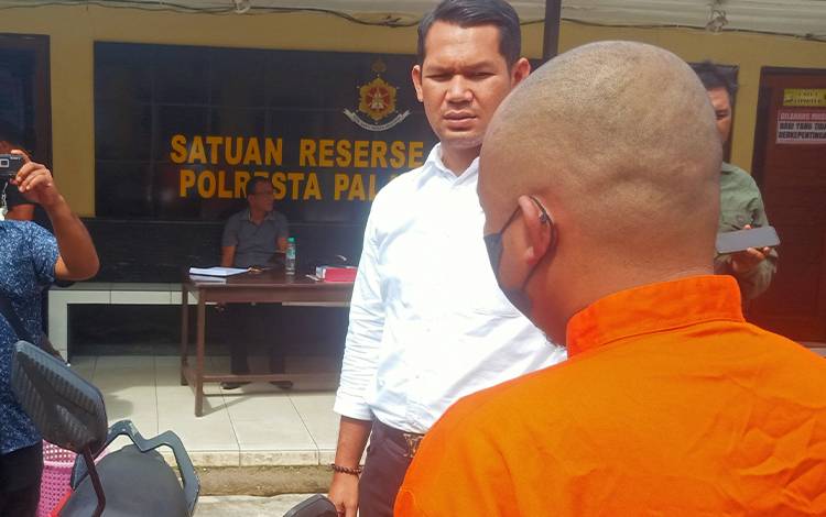 Kasat Reskrim Polresta Palangka Raya Kompol Ronny M Nababan membawa tersangka menunjukan barang bukti sepeda motor, Senin, 24 Oktober 2022. (POTO: PARLIN TAMBUNAN).