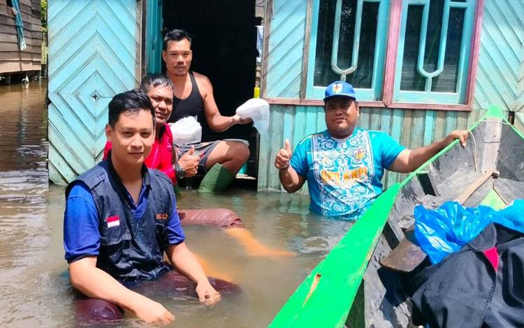 Ketua KNPI Endra Rosana kaos biru saat membagikan makanan dari dapur umum Agustiar Sabran, untuk korban banjir di Mentaya Hulu