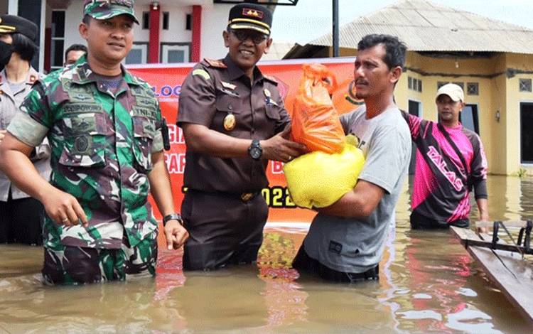 Kepala Kejaksaan Negeri Lamandau Hendra Jaya Atmaja menyerahkan bantuan sosial berupa paket sembako kepada warga terdampak banjir. (FOTO : HENDI NURFALAH)