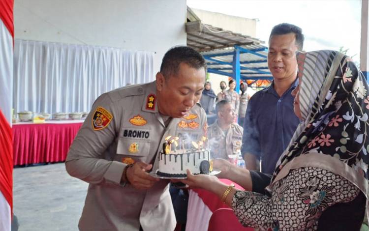 Kapolres Lamandau AKBP Bronto Budiyono meniup lilin di kue ulang tahun yang diberikan PWI Kabupaten Lamandau. (FOTO : ISTIMEWA) 