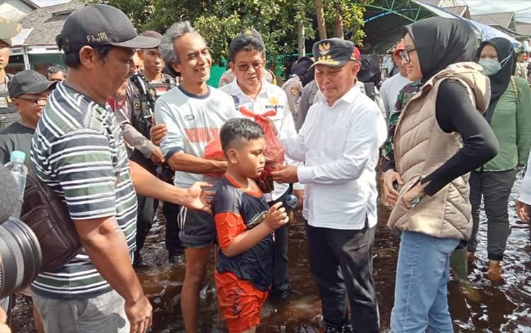Gubernur Kalimantan Tengah (Kateng), Sugianto Sabran menyerahkan bantuan kepada warga terdampak banjir di Kabupaten Sukamara, Sabtu, 29 Oktober 2022. (FOTO: NORHASANAH)