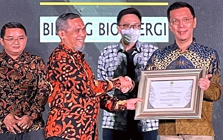Direktur Bioenergi Kementerian ESDM menyerahkan penghargaan kepada Business Head PT Wilmar Bioenergi Indonesia Teo Sian Uh