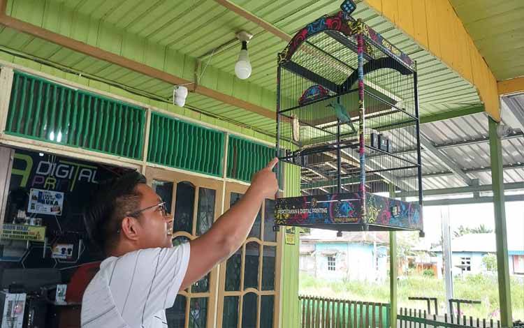 Supriadi selaku Ketua dari Komunitas Kicau Mania Kapuas Bersatu Bird Club (KBBC) menunjukkan burung peliharaannya yang kerap diikutikan di berbagai perlombaan. (FOTO: DODI)