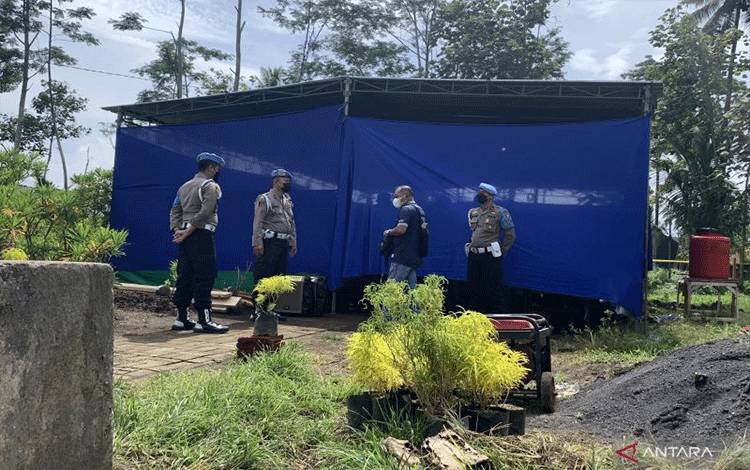 Petugas kepolisian berjaga di depan lokasi pelaksanaan autopsi di Tempat Pemakaman Umum Dusun Patuk, Desa Sukolilo, Kecamatan Wajak, Kabupaten Malang, Jawa Timur, Sabtu (5/11/2022). (ANTARA/Vicki Febrianto)