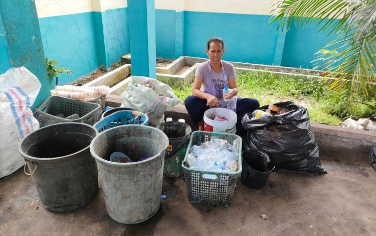 Salah seorang ibu-ibu di Kota Palangka Raya sedang memilah sampah (FOTO : NOPRI)