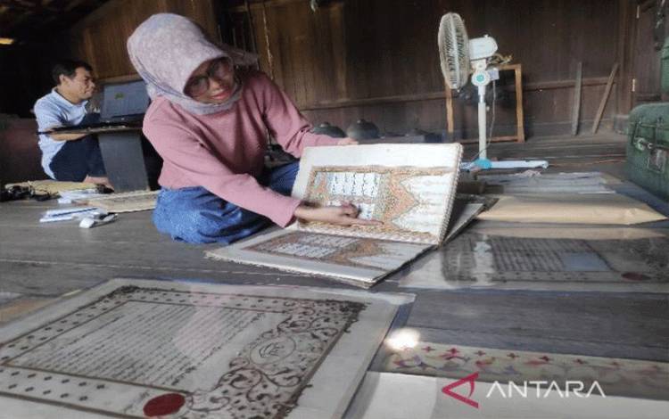 Husnul Fatimah menunjukkan Al-Quran manuskrip milik Istana Mangkubumi yang pernah dipamerkan pada Festival Istiqlal Jakarta Tahun 1995, Senin (7/11/2022). (ANTARA/M Husein Asyari)