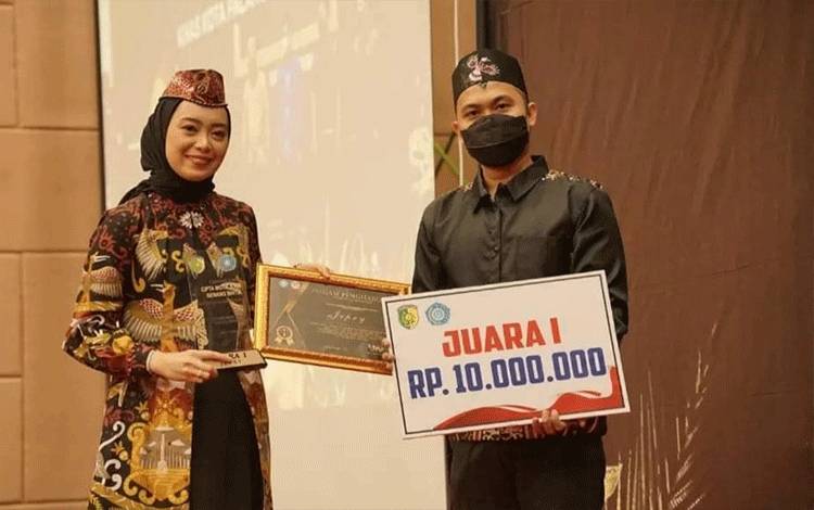 Ketua TP-PKK Palangka Raya, Avina Fairid Naparin menyerahkan hadiah pemenang lomba cipta batik kain benang bintik. (FOTO: HUMAS PEMKO)
