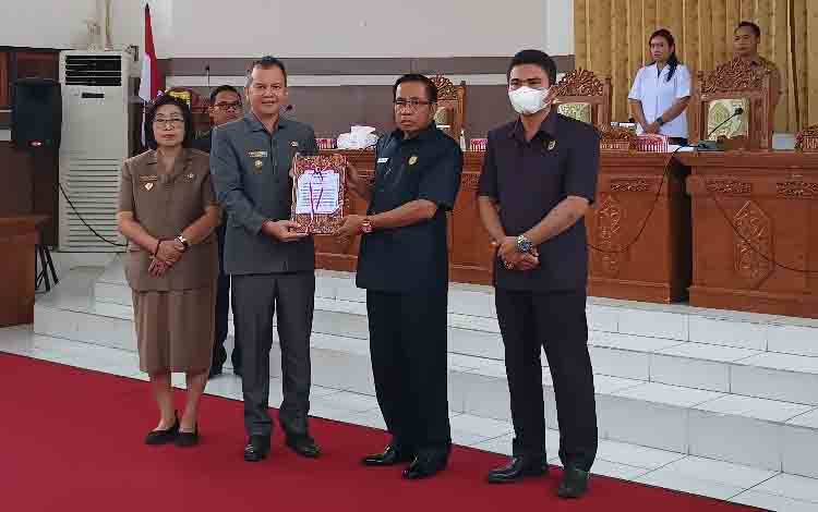 Bupati Gunung Mas Jaya S Monong didampingi Wakil Bupati Efrensia L.P Umbing menyerahkan dokumen RAPBD tahun 2023 dan lima Raperda lainnya di rapat paripurna yang dilaksanakan pada Senin, 14 November 2022 . (FOTO: RISKA YULYANA)