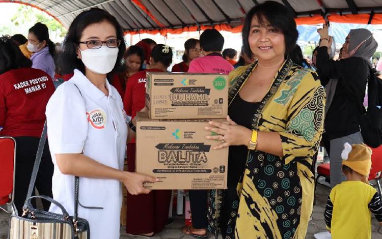  Ketua Komisi III DPRD Gunung Mas Iceu Purnamasari (kanan) saat menyerahkan bantuan makanan tambahan kepada sekretaris Dinas Kesehatan Rina Sari (kiri) , Jumat, 18 November 2022. (FOTO: RISKA YULYANA)