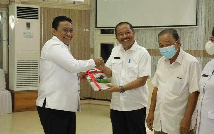 Wakil Gubernur Kalimantan Tengah (Kalteng), Edy Pratowo (kiri) menyerahkan secara simbolis Buku Grand Design Kalimantan Tengah 2045. (FOTO: IST)