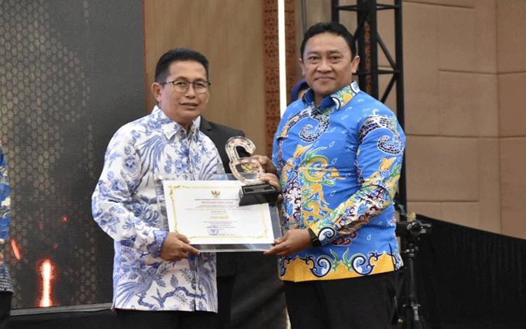 Wakil Gubernur Kalimantan Tengah (Kalteng), Edy Pratowo (kanan) saat menyerahkan piagam penghargaan kepada badan publik. (FOTO: IST)