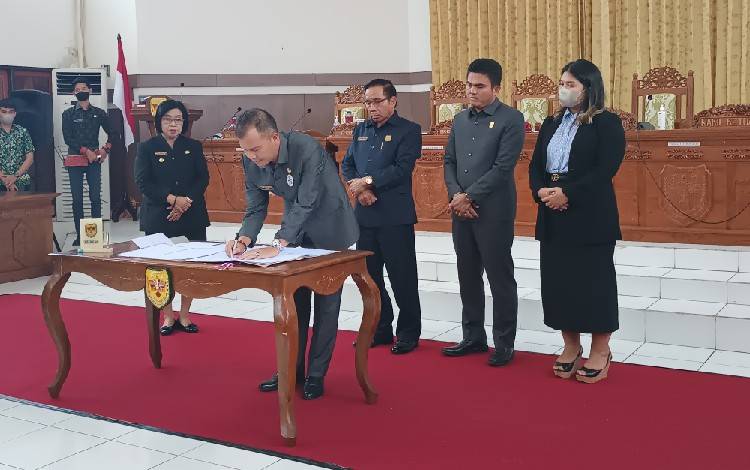 Bupati Gunung Mas Jaya S Monong saat menandatangani kesepakatan bersama dengan DPRD setempat terkait lima buah raperda, Jumat, 25 November 2022. (FOTO: RISKA YULYANA)