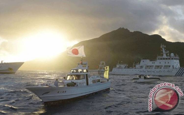 Kapal pengawas laut China Haijian No.51 (tengah) berlayar di dekat kapal-kapal Penjaga Pantai Jepang (kanan dan kiri) dan sebuah kapal nelayan Jepang (depan, kedua kiri), di perairan dekat Pulau Uotsuri, salah satu pulau dari kepulauan Senkaku/Diaoyu di Laut China Selatan, Senin (1/7). Jepang menghadapi ancaman serius yang semakin meningkat dari China dan Korea Utara, dalam laporan Kementerian Pertahanan Selasa kemarin, sementara politisi yang berkuasa menyerukan kepada militer untuk meningkatka