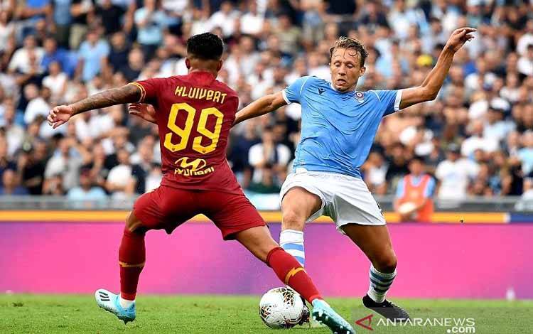 Arsip - Gelandang Lazio Lucas Leiva (kanan) dan sayap AS Roma Justin Kluivert (kiri) berebut bola dalam lanjutan Liga Italia di Stadion Olimpico, Roma, Italia, Minggu (1/9/2019) setempat. (ANTARA/AFP/Tiziana Fabi)