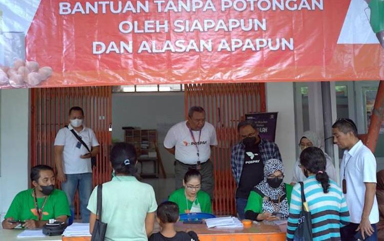 Direktur Bisnis Jasa Keuangan PT Pos Indonesia Haris ( kedua dari kiri berdiri belakang) meninjau penyaluran BLT BBM Tahap Ke 2 di Denpasar, Bali. (Antara/HO/Pos Indonesia)