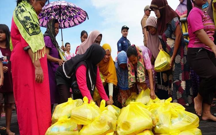 Warga terdampak banjir di Palangka Raya bergantian mengambil paket sembako yang disediakan pemerintah. (FOTO: HENDRI)