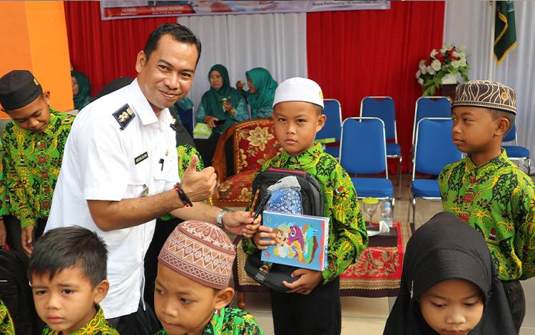 Lurah Kuala Pembuang I, Menteng Delpris menyerahkan bantuan perlengkapan sekolah kepada siswa di salah satu sekolah di Kelurahan Kuala Pembuang I. (FOTO: ISTIMEWA)