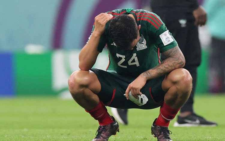Gelandang Meksiko Luis Chavez tertunduk lesu setelah gagal melaju ke babak 16 besar meski menang atas Arab Saudi dengan skor 2-1 di pertandingan terakhir Grup C Piala Dunia 2022 di Lusail Stadium, Lusail, Qatar, Rabu (30/11/2022). (AFP/KARIM JAAFAR)