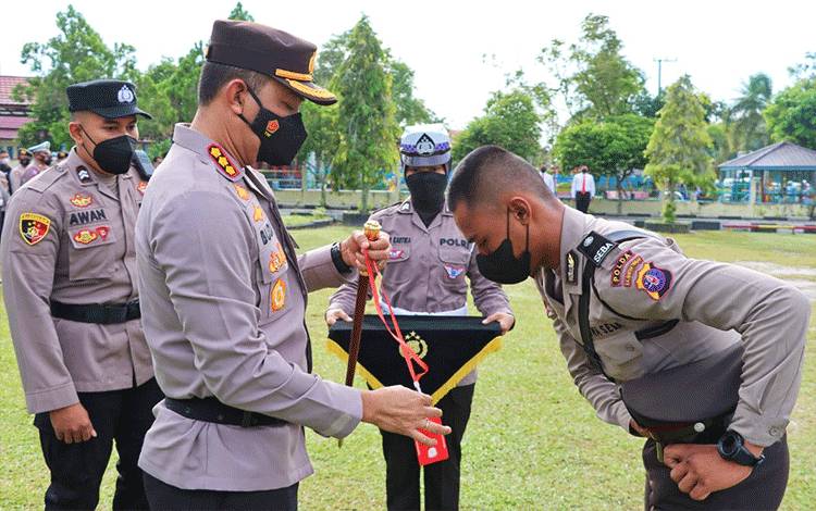Kapolresta Palangka Raya Kombes Budi Santosa saat melepaskan tanda magang (Latja) kepada salah satu Siswa, Kamis, 1 Desember 2022. (POTO : PARLIN TAMBUNAN)