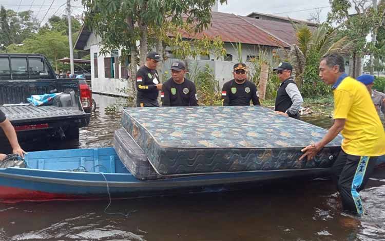 Tim penanangan bencana banjir Kabupaten Sukamara saat membantu mengevakuasi barang milik warga terdampak banjir. (FOTO: NORHASANAH)