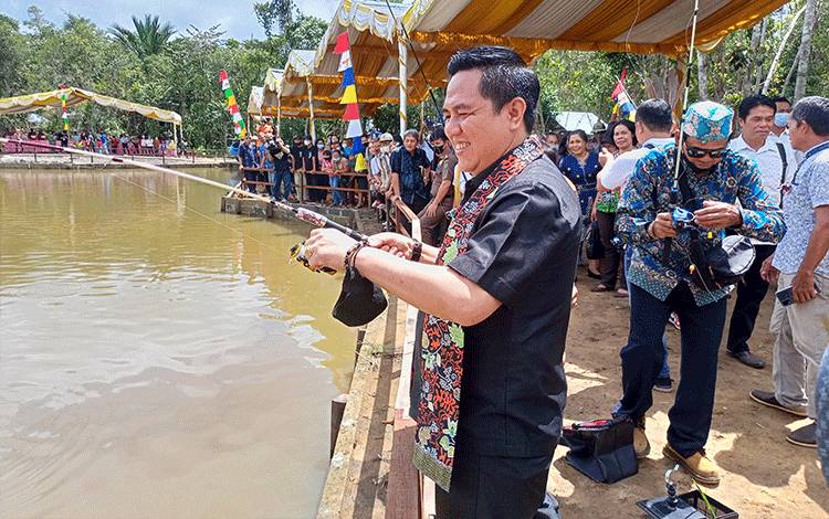 Wakil Ketua I DPRD Barito Timur Ariantho S Muler saat mencoba memancing ikan di kolam pemancingan Objek Wisata Alam Luaw Banse Desa Jaweten, Senin, 5 Desember 2022. (FOTO: BOLE MALO)
