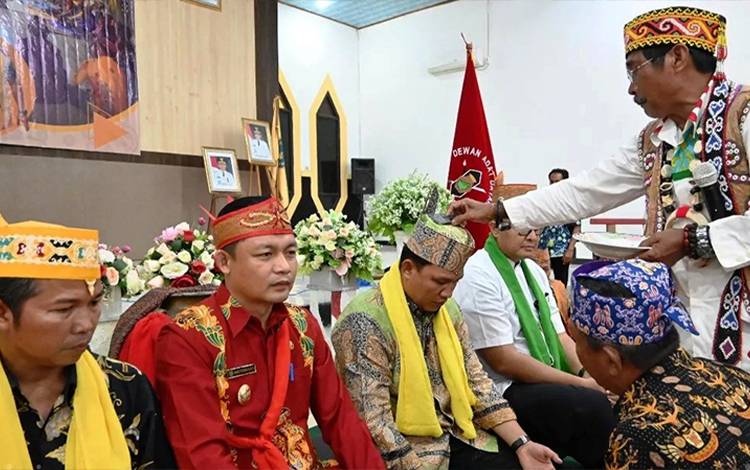 Bupati Lamandau Hendra Lesmana bersama sejumlah tokoh masyarakat menjalani prosesi Penggolaran atau pemberian gelar adat. (FOTO: HENDI NURFALAH)