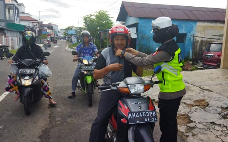 Personel Satuan Lalu Lintas, saat meminta pengendara untuk meng klik helm (Foto : Polres Seruyan)