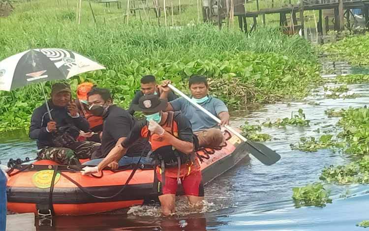 Tim melakukan evakuasi jasad korban mendayung menggunakan perahu karet, Kamis 8 Desember 2022. (POTO : PARLIN TAMBUNAN)