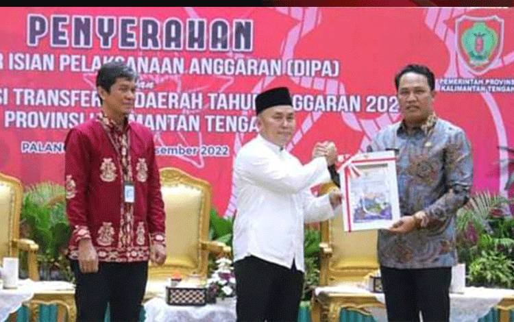 Bupati Lamandau Hendra Lesmana saat menerima DIPA tahun anggaran 2013 dari Gubernur Kalteng Sugianto Sabran.(FOTO : HENDI NURFALAH)