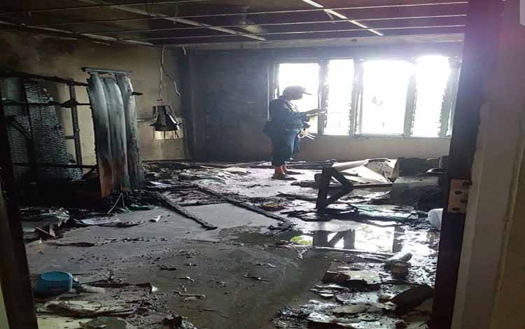 Komandan 1 Damkar Kota Sucipto saat melihat kondisi ruangan yang terbakar usai di padamkan setelah terbakar.(Foto : Agus Fataroni M)