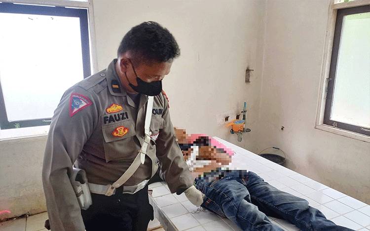 Kanit Gakkum Satlantas Polres Barito Timur Ipda Ahmad Fauzi saat memeriksa jenazah korban kecelakaan di Ruang Jenazah RSUD Tamiang Layang. (FOTO: BOLE MALO)